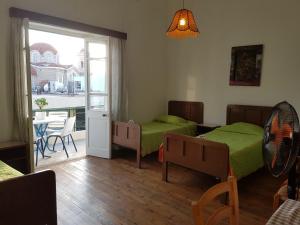 een slaapkamer met 2 bedden, een tafel en een patio bij Trianon in Paphos City