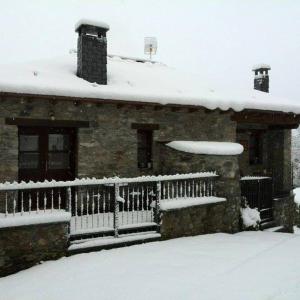 ein Haus mit einem schneebedeckten Dach mit einem Zaun in der Unterkunft Casa Gloria in Moncó