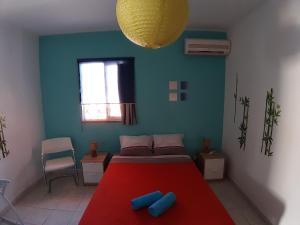 1 dormitorio con cama roja y pared azul en Alameda Hostel, en Portimão