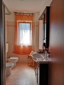 a bathroom with a sink and a toilet and a window at Casa al mare Palizzi Marina in Palizzi Marina