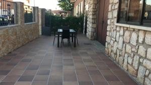 a patio with a table and chairs next to a building at Vivienda uso turistico Atalaya in El Burgo de Osma +5 photos