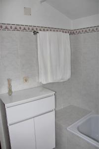 a white bathroom with a sink and a towel at Casa São João in São Salvador da Aramenha +6 photos