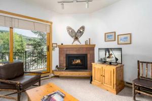 a living room with a fireplace and a table at Snow Flower Condos in Steamboat Springs