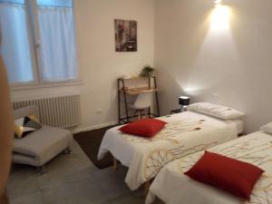 a hotel room with two beds and a chair at The judas trees in Mestre +31 photos