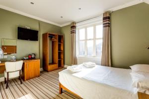 a bedroom with a bed and a desk and a window at Bawn Lodge in Chester