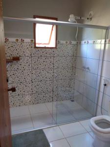 a bathroom with a shower and a toilet at Chalé da Sorte in Gonçalves