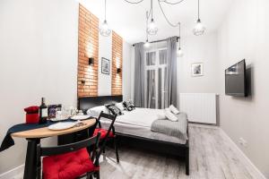 um pequeno quarto com uma cama, uma mesa e cadeiras em Dietla 32 Residence - ideal location in the heart of Krakow, between Main Square and Kazimierz District na Cracóvia