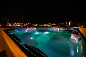 a hot tub on a balcony at night at Penthouse Retreat in Cospicua