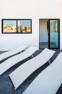 a row of white tables in a room with windows at Penthouse Retreat in Cospicua