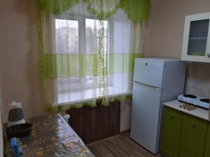 une cuisine avec un réfrigérateur blanc et une fenêtre dans l'établissement Lux Apartment on Potanina 19, à Öskemen