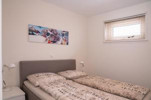 uma cama com duas almofadas num quarto em Santvort Luxury Apartment with Private Parking em Zandvoort