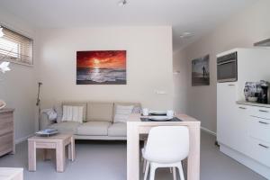 a living room with a couch and a table at Santvort Luxury Apartment with Private Parking in Zandvoort