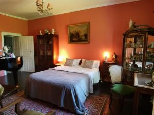 ein Schlafzimmer mit orangefarbenen Wänden und ein Bett in einem Zimmer in der Unterkunft Presbytere in Sauville