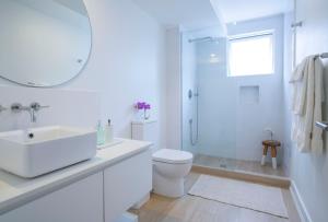 a white bathroom with a sink and a shower at Mullins Grove in Saint Peter