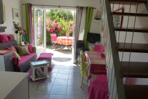 a living room with pink couches and a table with a table at Le Diamant in Le Minihic-sur-Rance