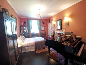 - une chambre avec un lit et un piano dans l'établissement Presbytere, à Sauville