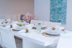 a white dining table with white dishes and chairs at Mullins Grove in Saint Peter