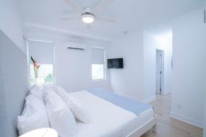 a white bedroom with a bed with white pillows at Mullins Grove in Saint Peter