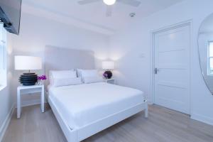 a white bedroom with a white bed and a white door at Mullins Grove in Saint Peter