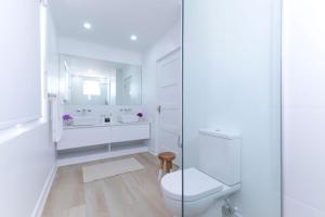 a white bathroom with a toilet and a sink at Mullins Grove in Saint Peter