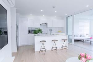 a white kitchen with two stools and a counter at Mullins Grove in Saint Peter
