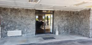 a front door of a building with a stone wall at Executive Inn in Corpus Christi