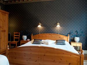um quarto com uma cama de madeira e papel de parede com bolinhas azuis em Eklanda Bed & Breakfast em Gotemburgo