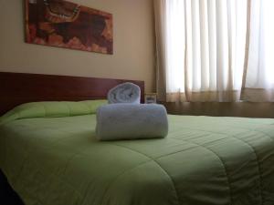 a bed with a laptop sitting on top of it at Hotel Sumaq Inn Sac in Lima