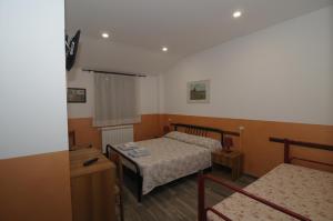 Cette petite chambre comprend deux lits et une table. dans l'établissement Azienda Agrituristica Pericle, à Montella