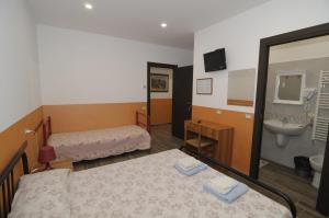 een kamer met 2 bedden en een badkamer met een wastafel bij Azienda Agrituristica Pericle in Montella