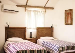twee bedden naast elkaar in een kamer bij Palapas Ventana in La Ventana