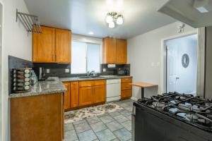 cocina con armarios de madera y horno con fogones en @ Marbella Lane 5BR House in Downtown Redwood City, en Redwood City