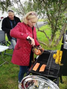 a woman is cooking food on a grill at Iceland Igloo Village in Hella