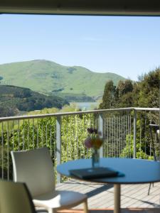 a table and chairs on a balcony with a view at Hereweka Garden Retreat in Dunedin