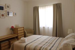 een slaapkamer met een bed en een raam bij Casinha dos Avós in Lagos