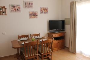 een eetkamer met een tafel en een televisie bij Casinha dos Avós in Lagos