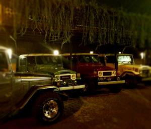 een rij vrachtwagens geparkeerd op een parkeerplaats 's nachts bij Helios Hotel Malang in Malang