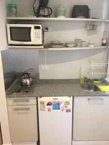 uma pequena cozinha com um micro-ondas e um frigorífico em Studio Palermo La Rural y Embajada USA em Buenos Aires