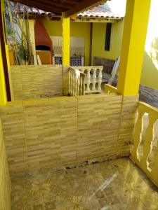 a wooden fence in front of a house at Vilmar suítes in Maricá