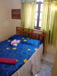 um quarto com uma cama com um edredão azul e amarelo em residência móvel em marica em Maricá