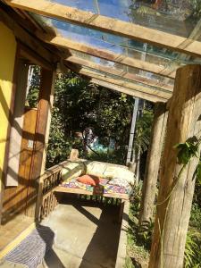 a wooden pergola with a bed on a porch at Chalés Luz da Montanha in Núcleo Mauá