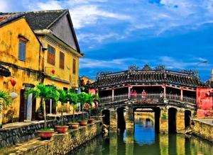 a bridge over a river next to some buildings at Family Hotel in Hoi An