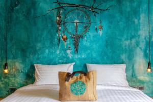 een slaapkamer met een bed met een blauwe muur bij Dreamcatcher Boutique Hotel in Bophut