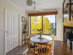 uma sala de jantar com uma mesa e cadeiras e uma janela em Bonnie Brae Cottage em Hepburn Springs