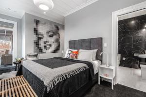 a bedroom with a large bed and a bathroom at Franklin38 in Auckland