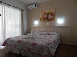 a bedroom with a bed and a painting on the wall at Pousada Salines in Florianópolis