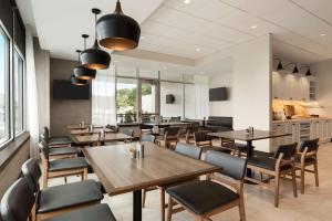 a dining room with wooden tables and chairs at Hyatt Place Virginia Beach Town Center in Virginia Beach