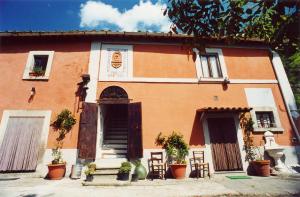 an orange building with chairs and plants in front of it at La Meridiana Strana in Viterbo