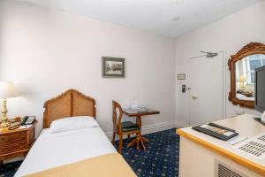 1 dormitorio con 1 cama y escritorio con ordenador en Castlereagh Boutique Hotel, Ascend Hotel Collection, en Sídney