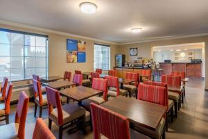 un restaurante con mesas de madera y sillas rojas en Comfort Inn & Suites El Centro I-8, en El Centro